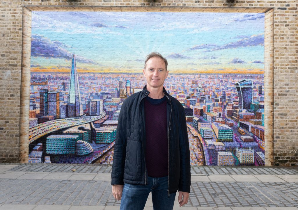 Artist Jimmy C standing in front of his London Skyline artwork