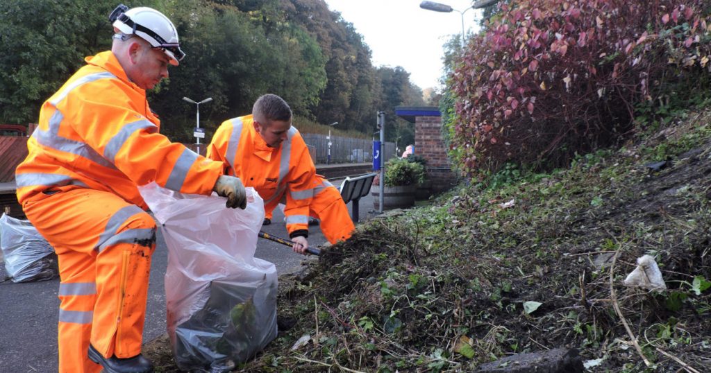 Volunteers pick litter at a railway station, daytime