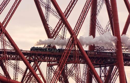 Steam train travelling over Forth Bridge