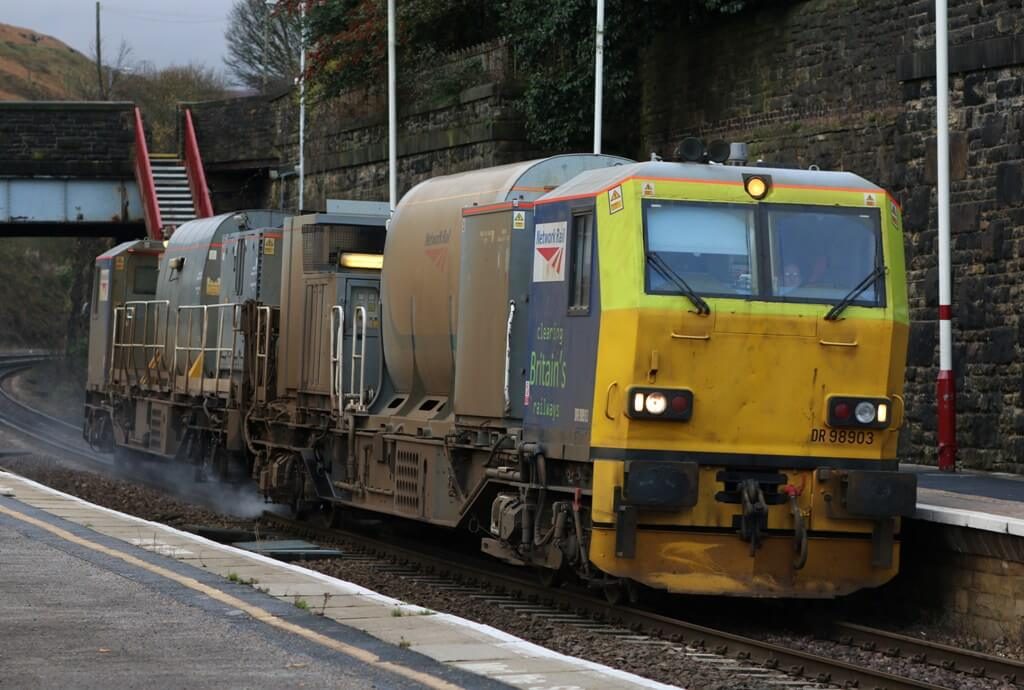 A multipurpose vehicle ready for winter, driving through a station