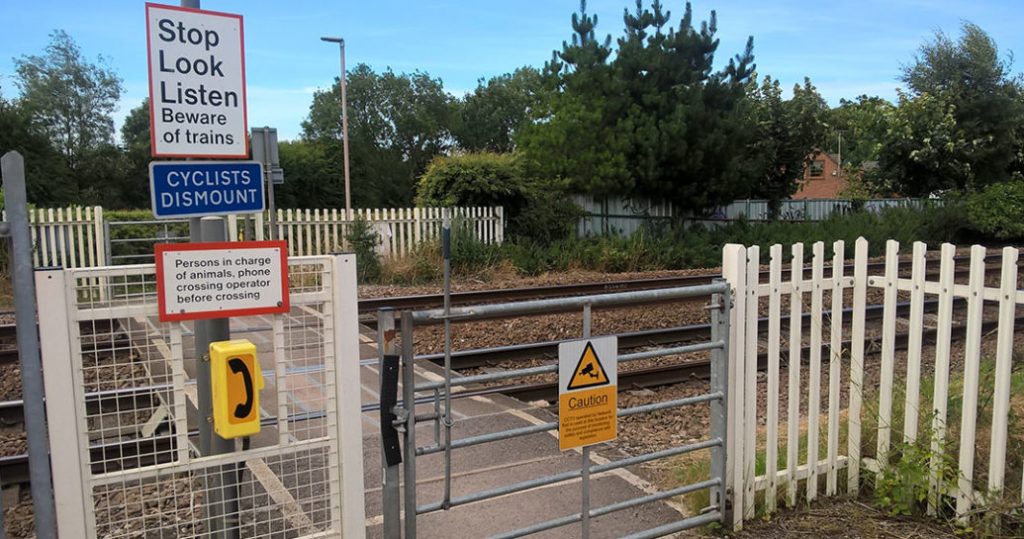 Kings Mill Lane level crossing with safety notices.