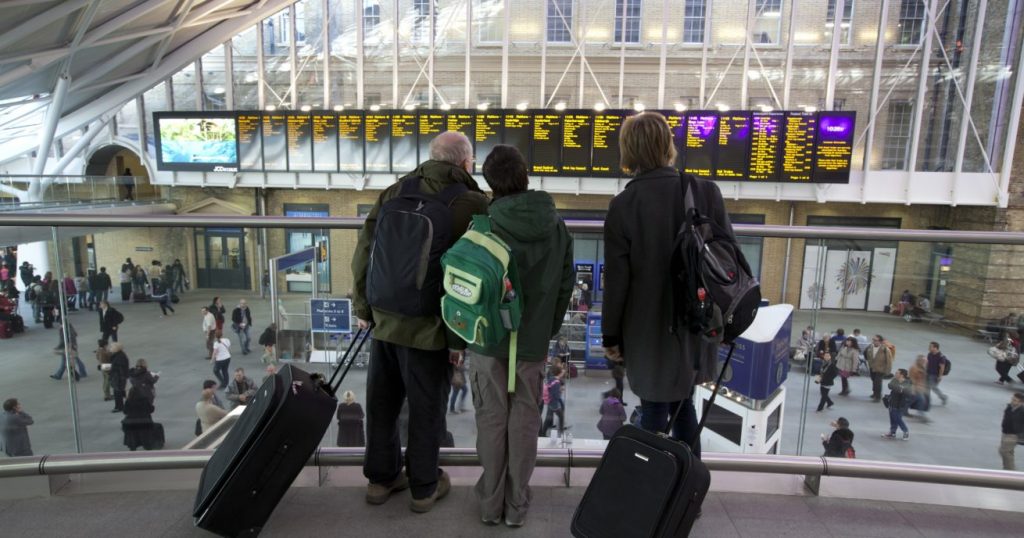 Passengers looking at departure board at King's Cross