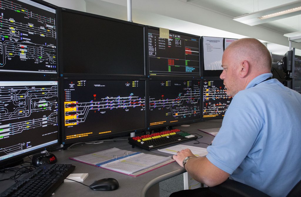 Signaller sitting at bank of screens