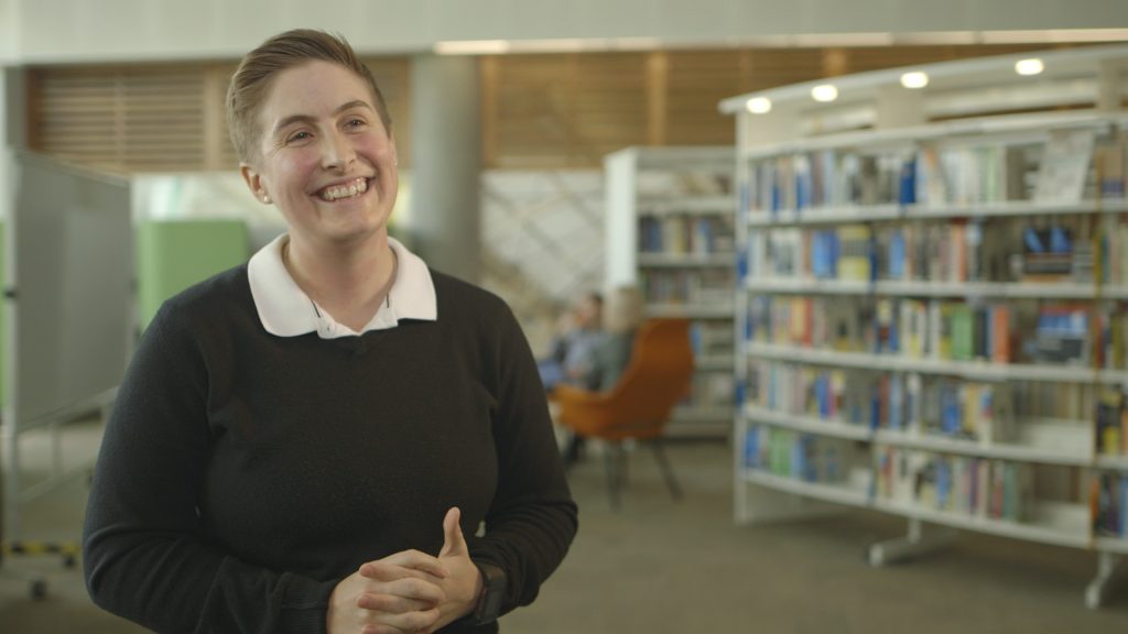 Tara Scott, route engineer, smiling whilst standing in a Network Rail library