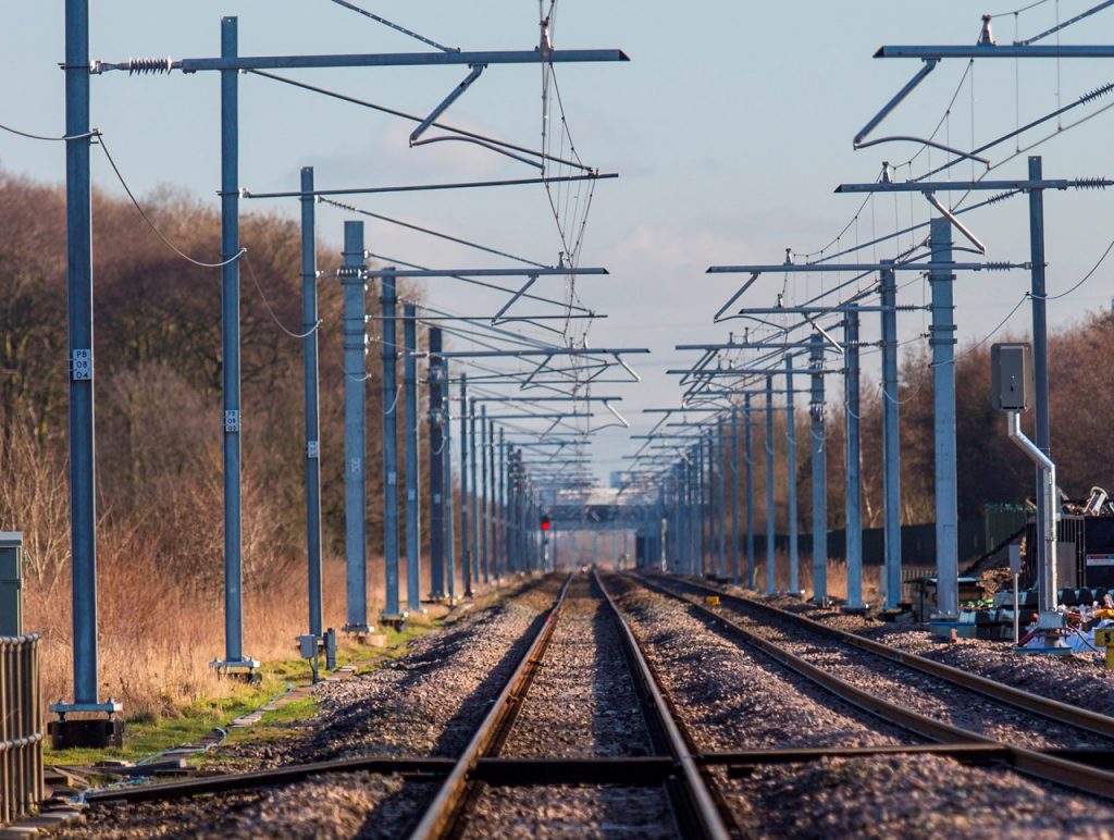 Railway tracks and overhead line equipment on a sunny day.