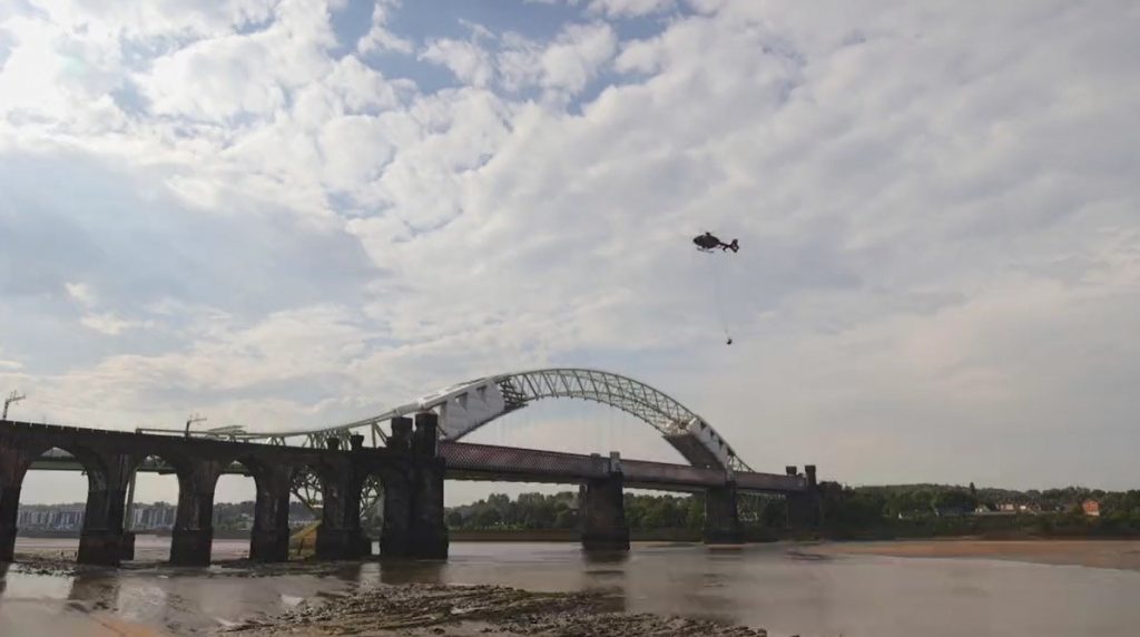 The Network Rail helicopter lifts the bell off the Runcorn bridge, daytime