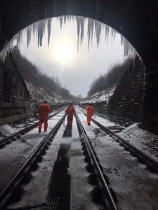 Icicles formed on the top of a tunnel, with ice and snow on the train tracks