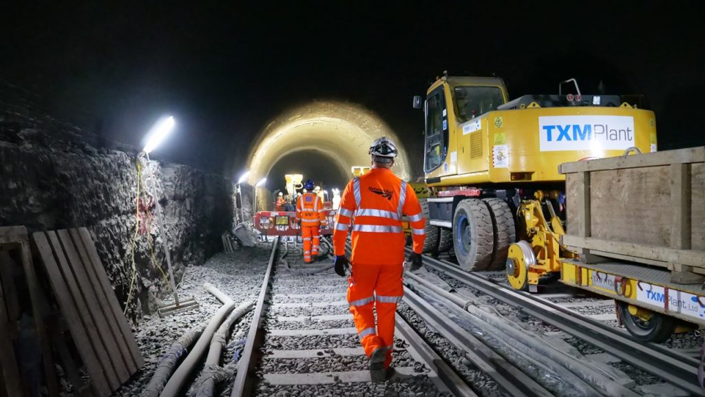Network Rail engineer walking down a tunnel towards work taking place at night time