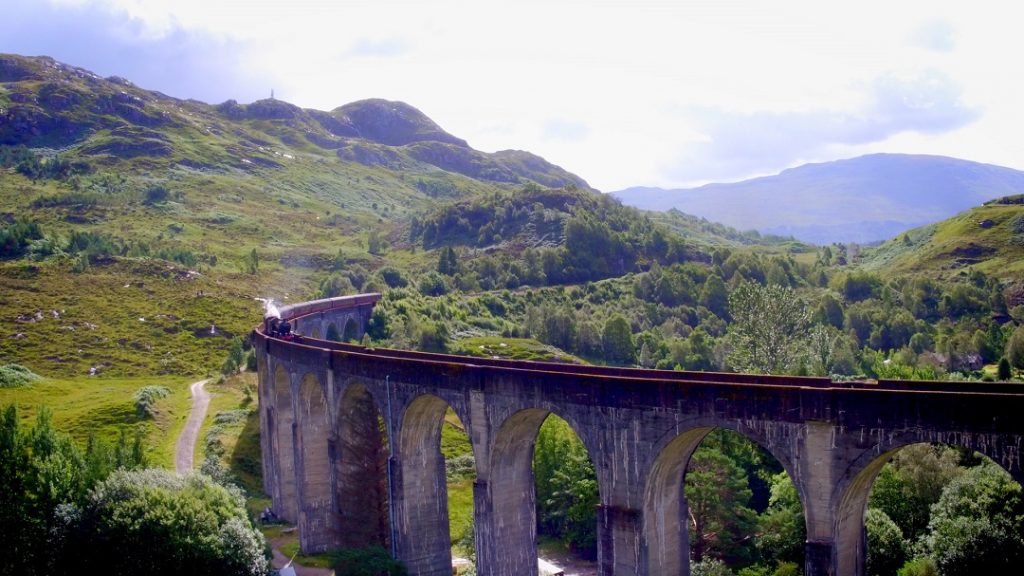 The Jacobite steam train crossing the Glenfinnan Viaduct in the Scottish Highlands, daytime