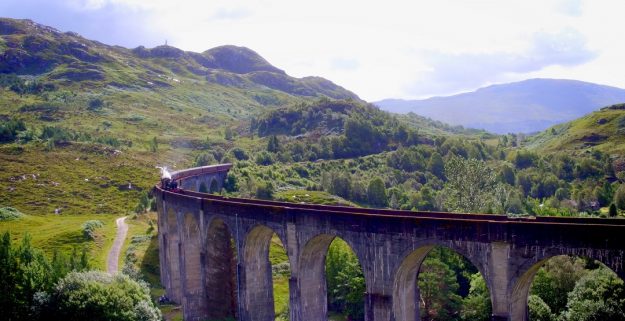 The Jacobite steam train crossing the Glenfinnan Viaduct in the Scottish Highlands, daytime