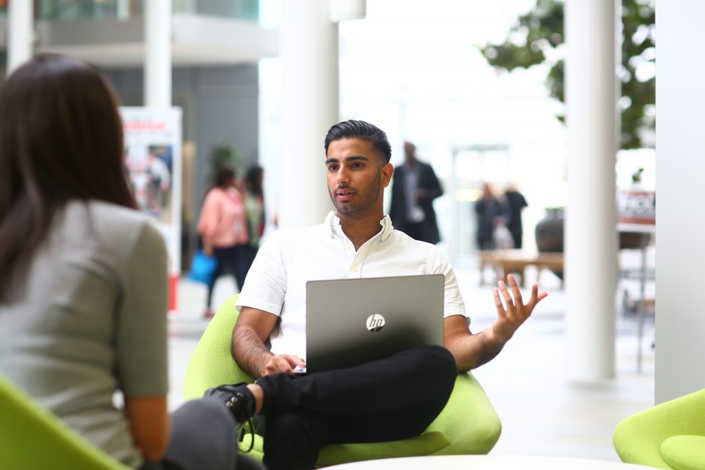 Two Year in Industry students having a conversation in an office