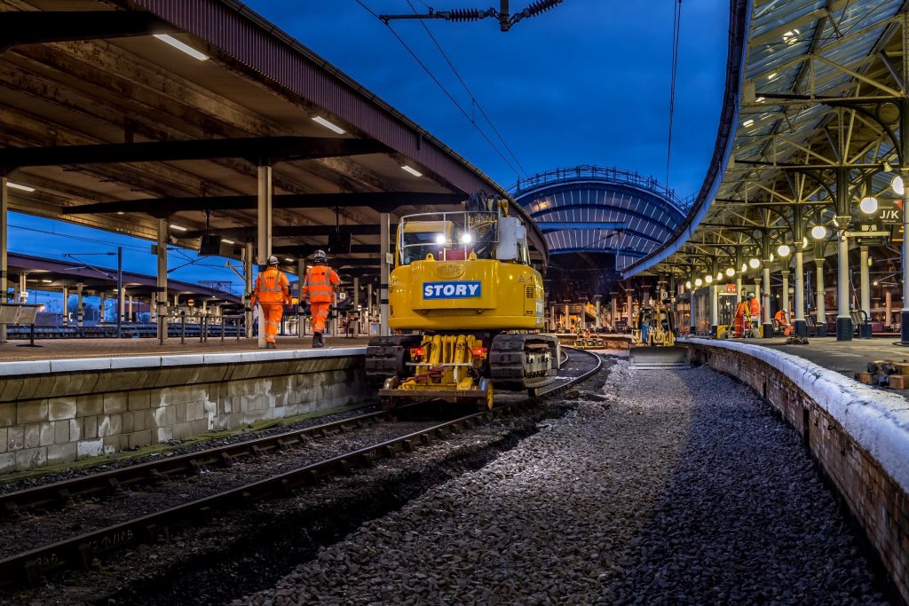 engineers on a station platform at York with engineering equipment on the track and the station in background