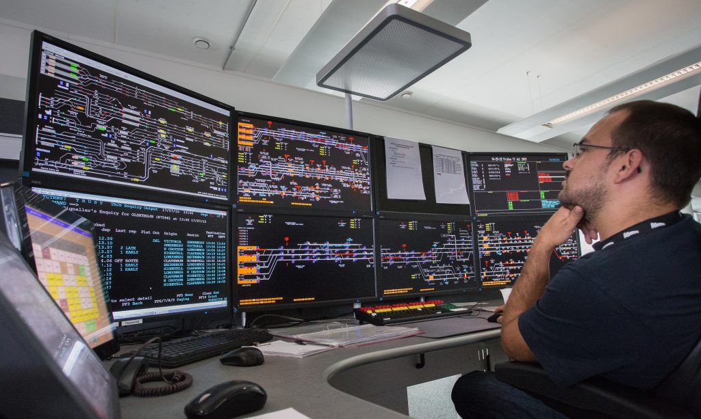 A signaller sat looking at digital signalling screens