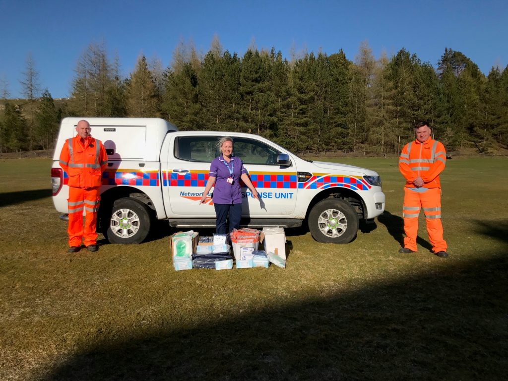 Volunteers from Network Rail and a nurse in front of a Network Rail vehicle, daytime