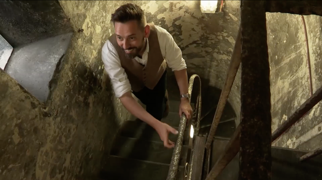 Presenter Tim Dunn climbing up the clock tower at London King's Cross