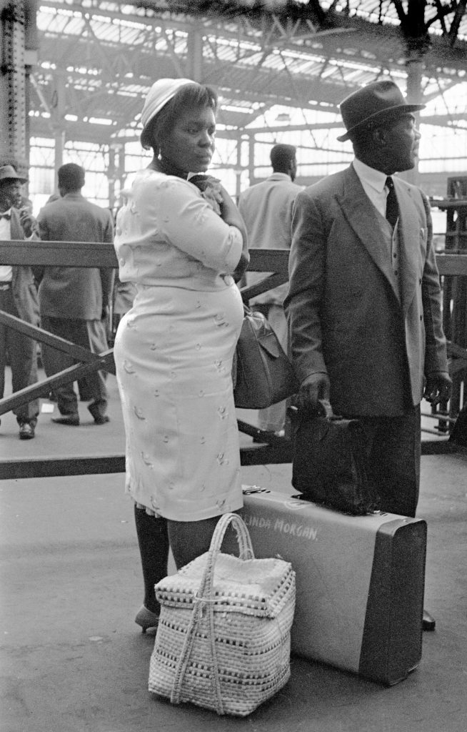 A young couple at London Waterloo railway station in the 1960s with their luggage