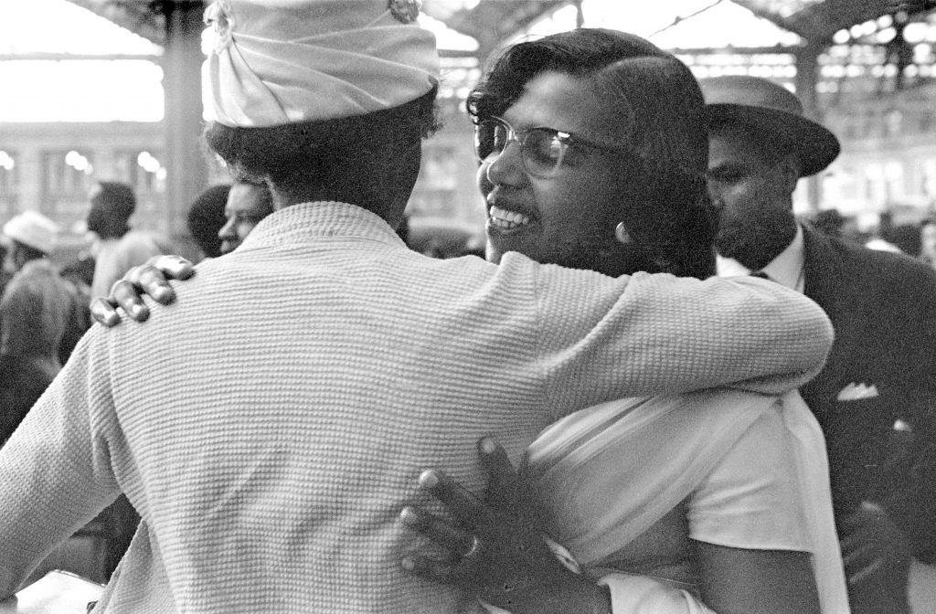 Black and white photo from the 1960s of women hugging at London Waterloo station