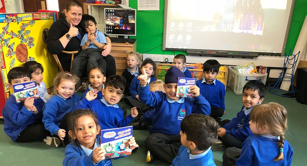 Children at Bradford school holding up "Stay safe with Thomas" book. 