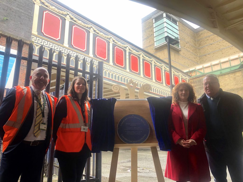 Staff members from Network Rail and the Railway Heritage trust standing either side of the plaque unveiling 