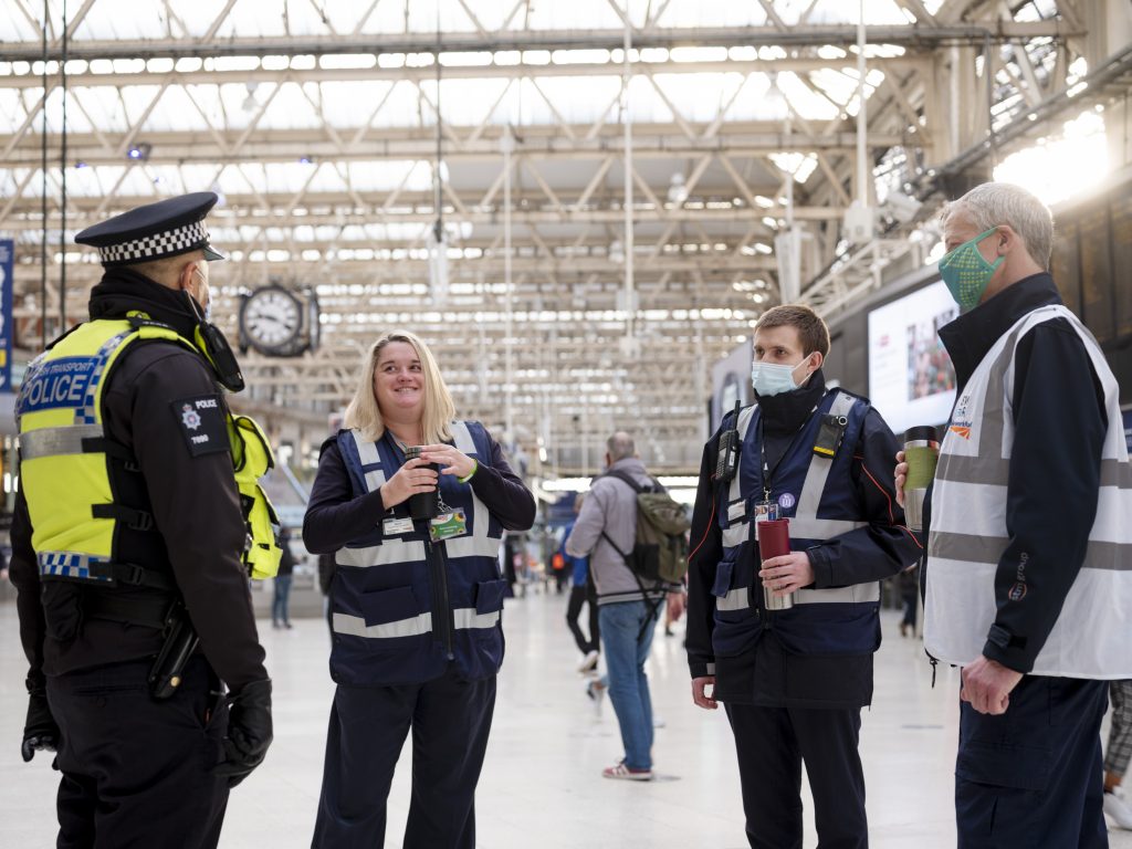 A police officer and station staff chat on the concourse at London Waterloo station