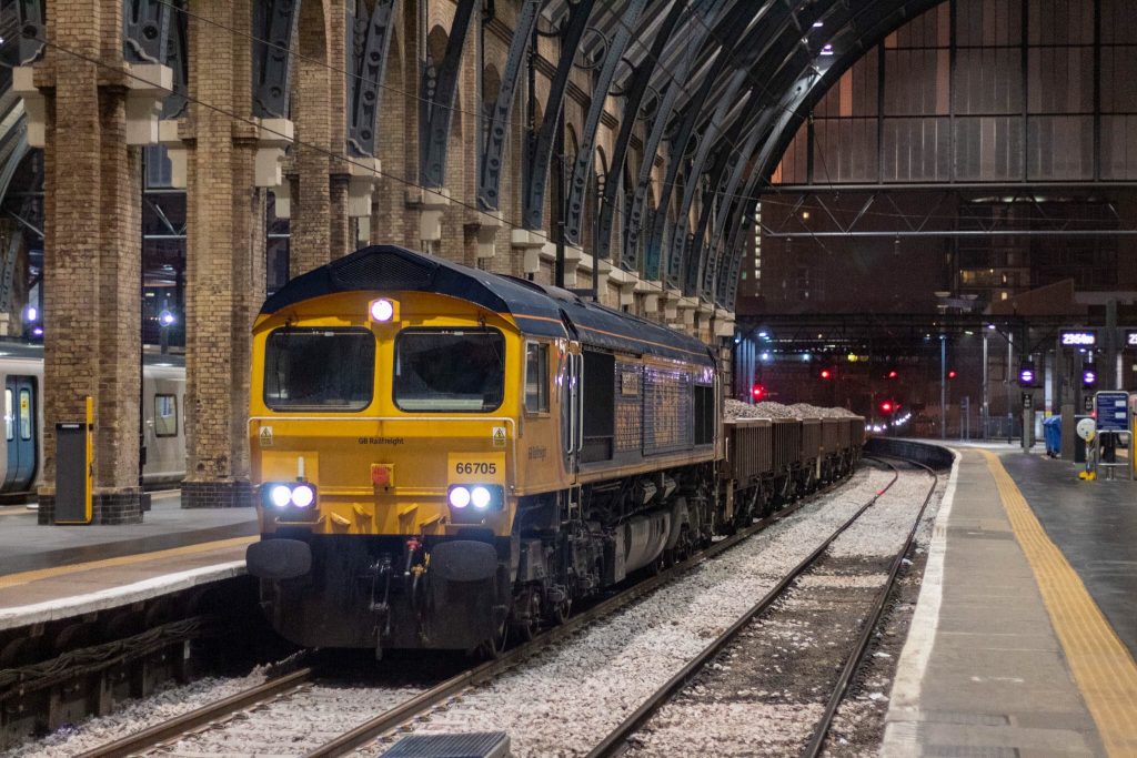 Freight train carrying ballast at London King's Cross station, nighttime