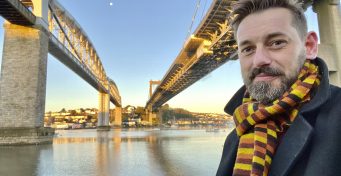 Presenter Tim Dunn stands in front of the Royal Albert Bridge and the Tamar Bridge beside it, daytime