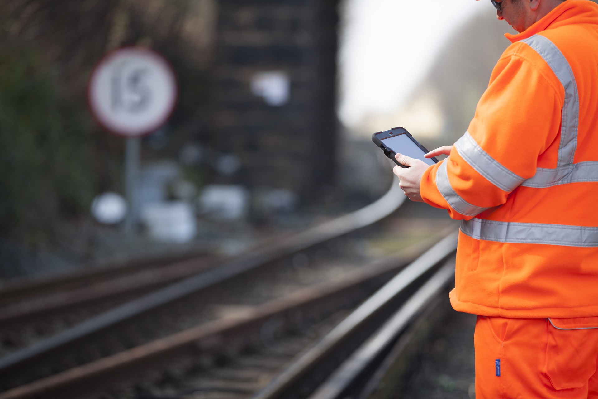 A Network Rail worker using an iPad to manage trackside data