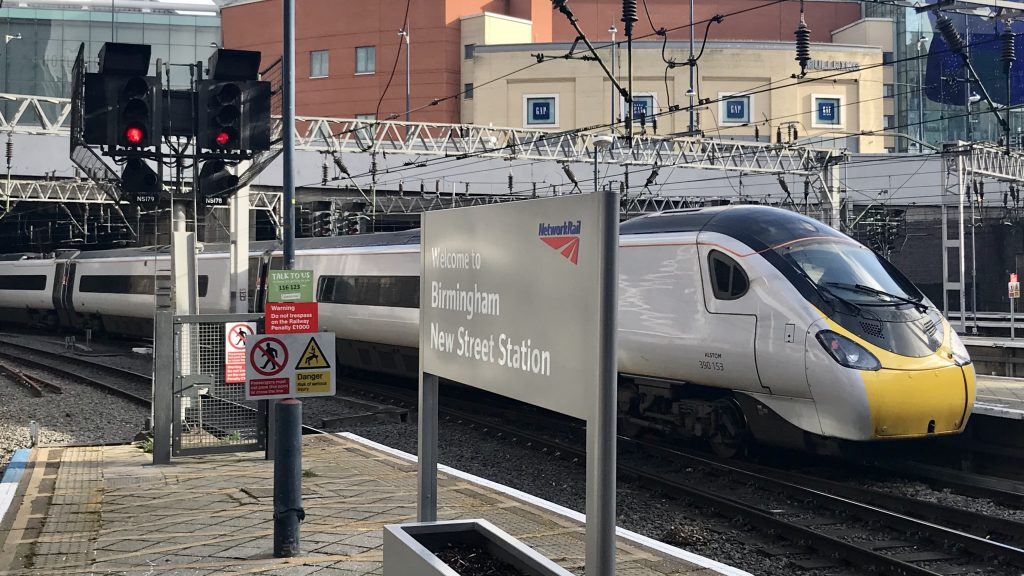 A train pulling out of Birmingham New Street station, daytime