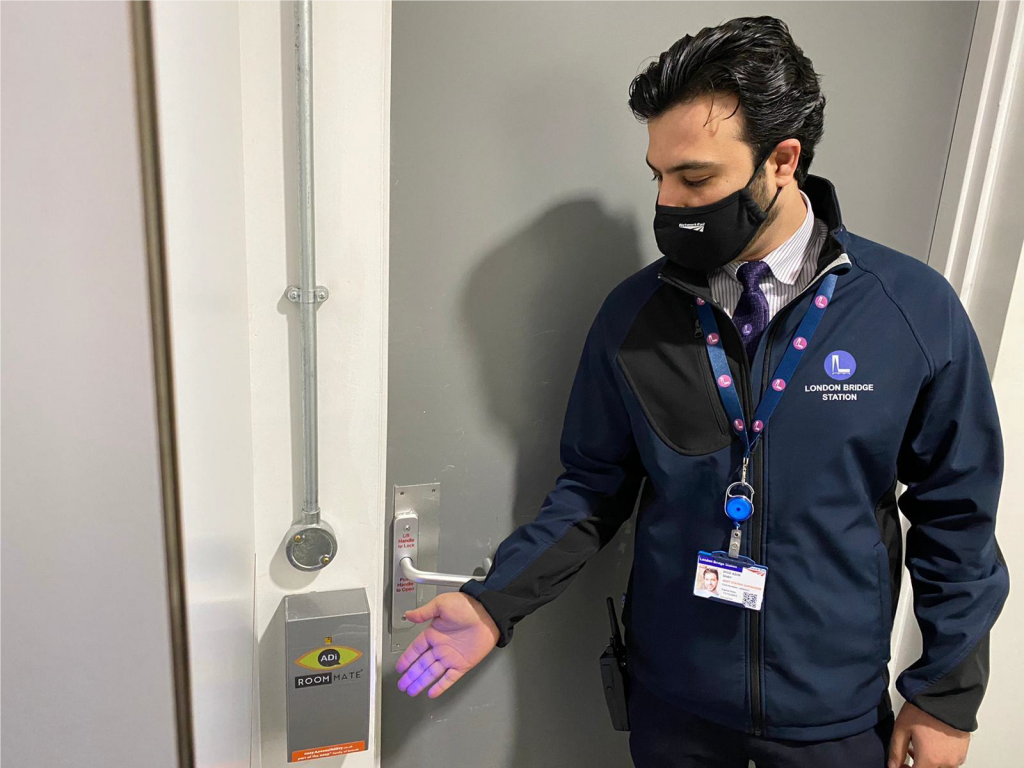 Network Rail station staff member next to the RoomMate technology outside a station toilet