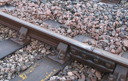 Close up of older-style bullhead rail, fastened to a 'chair' on the sleeper