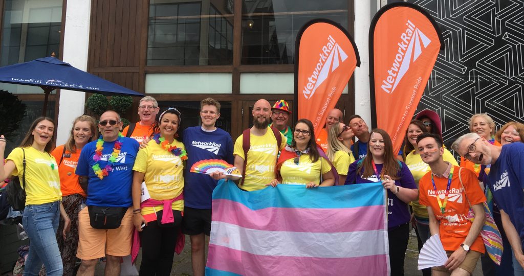 Network Rail employees with bright tshirts and banners to celebrate LGBT Pride
