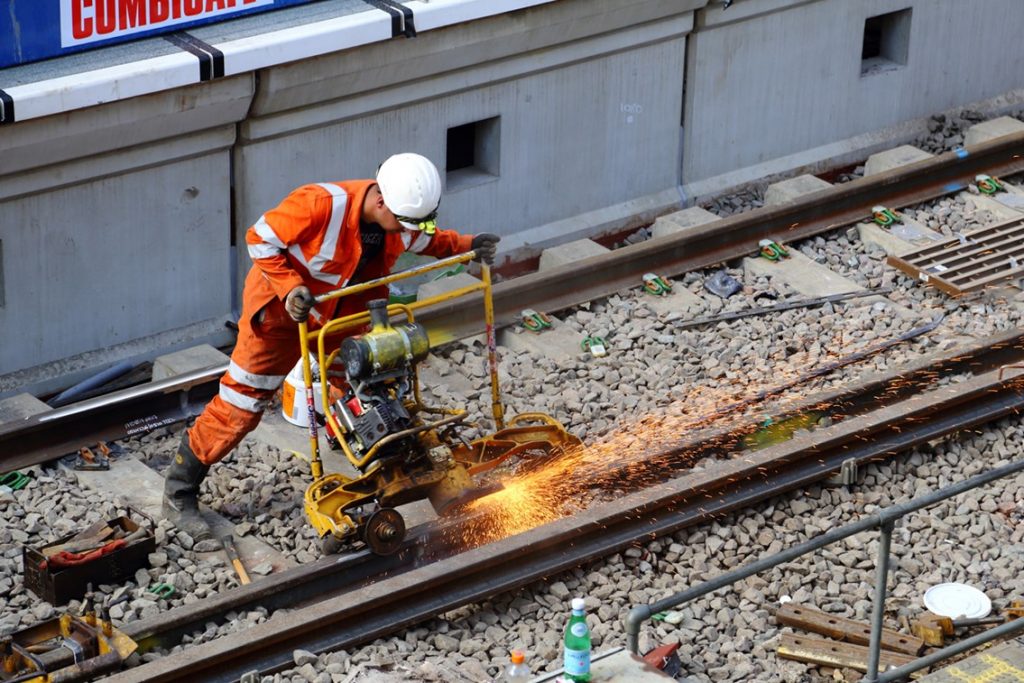 A rail worker in PPE working on track in South London.