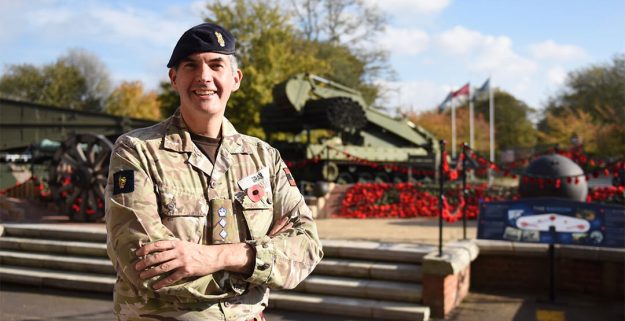 Darin Gray, reservist, in uniform in front of poppy display, daytime