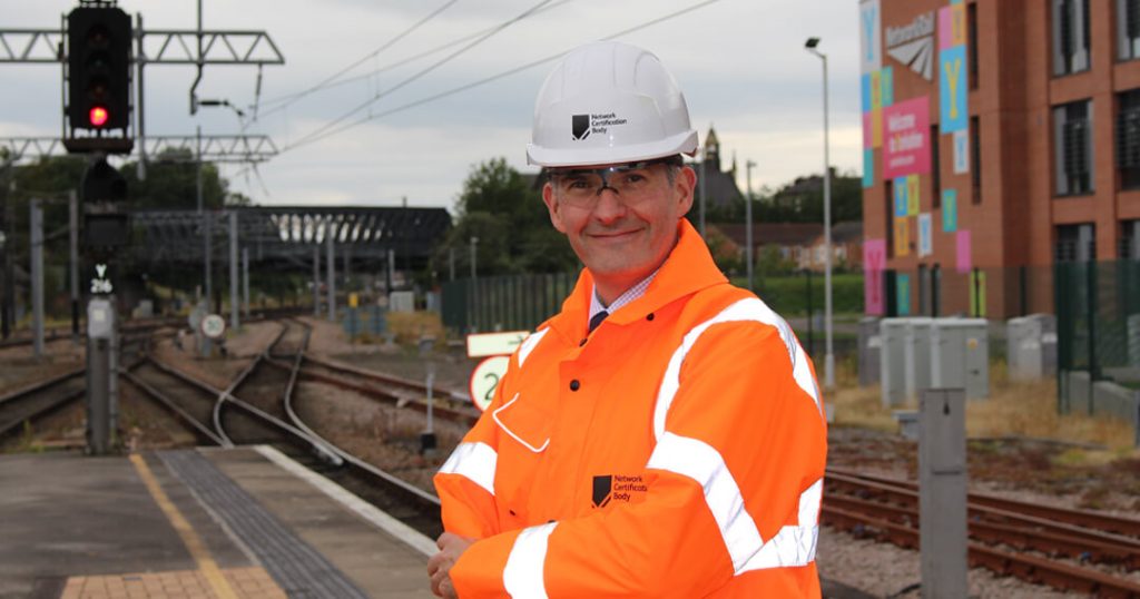 Darin Gray, reservist, in Network Rail PPE on railway station platform, daytime