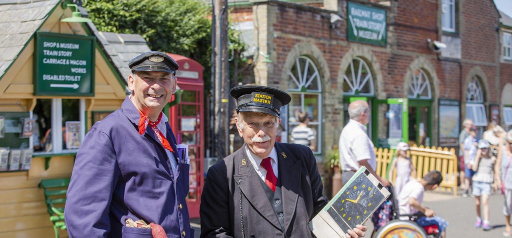 Re-enactors outside a station on the Isle of Wight Railway, a heritage railway, daytime