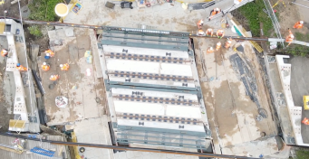 Aerial view of workers replacing bridge over a river, late May bank holiday, 2021, daytime