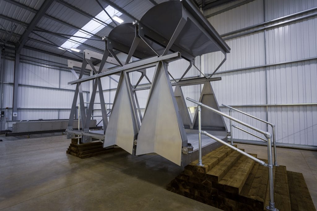 A large section of the stainless steel AVA bridge sits in a warehouse