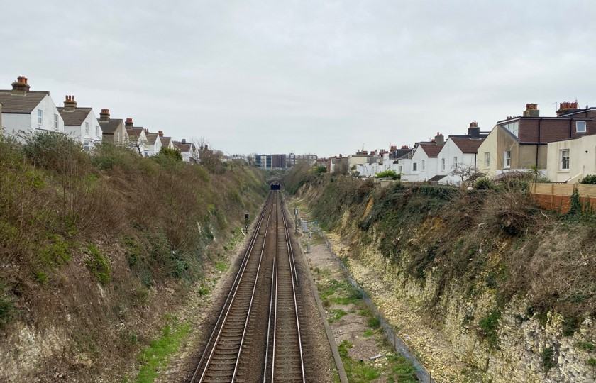 Train track running through the middle of railway cutting in Hove