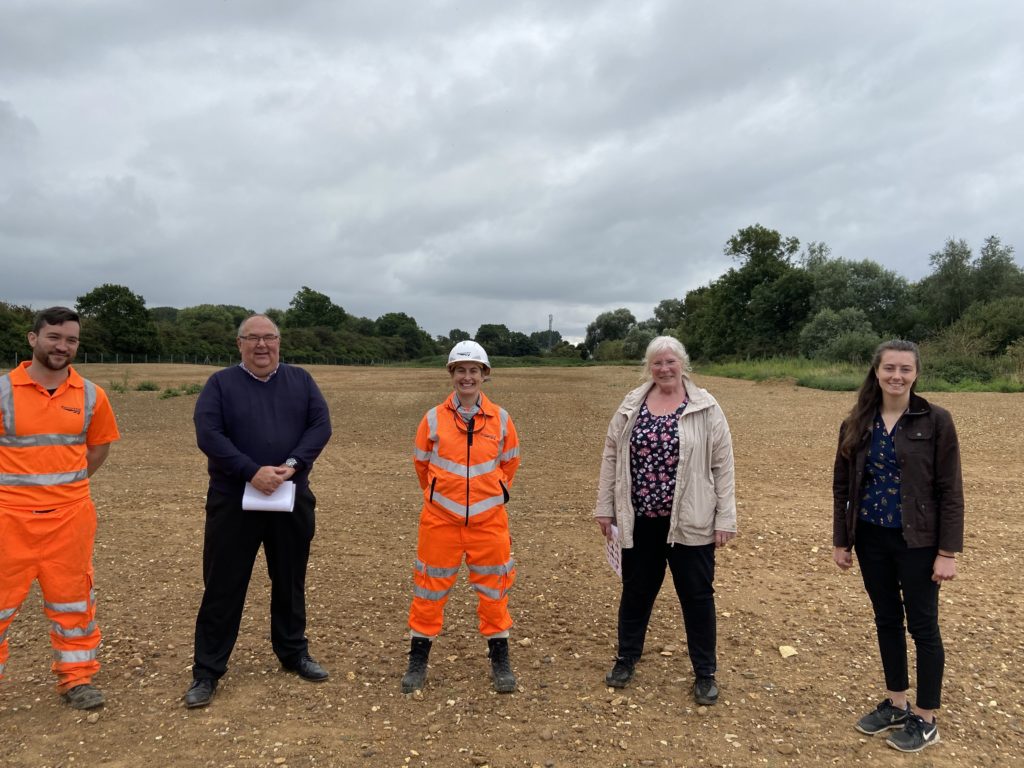 Tara Scott and Hamish Critchell-Ward from Network Rail in a field with local residents, daytime