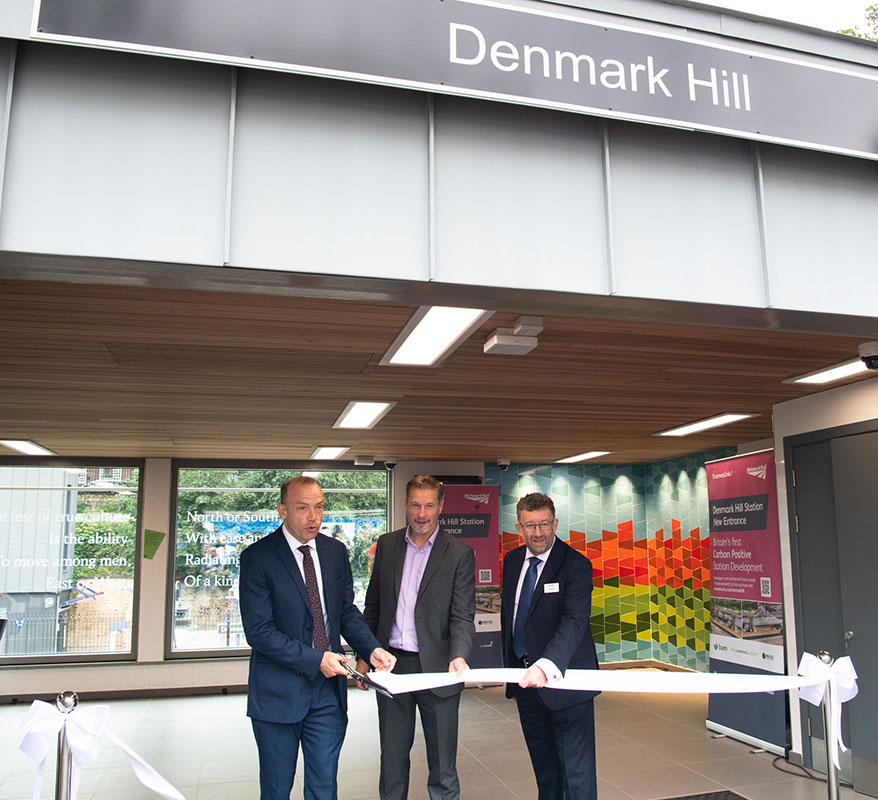 Ribbon being cut at the opening of Denmark Hill Station underneath the station sign