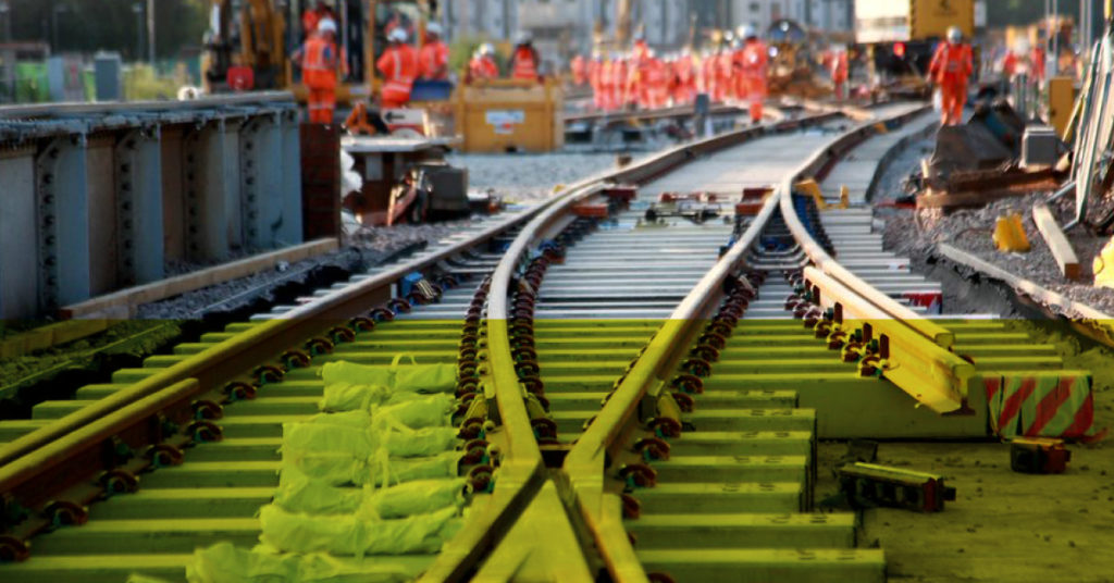 Close up of rail track with engineers working in the background