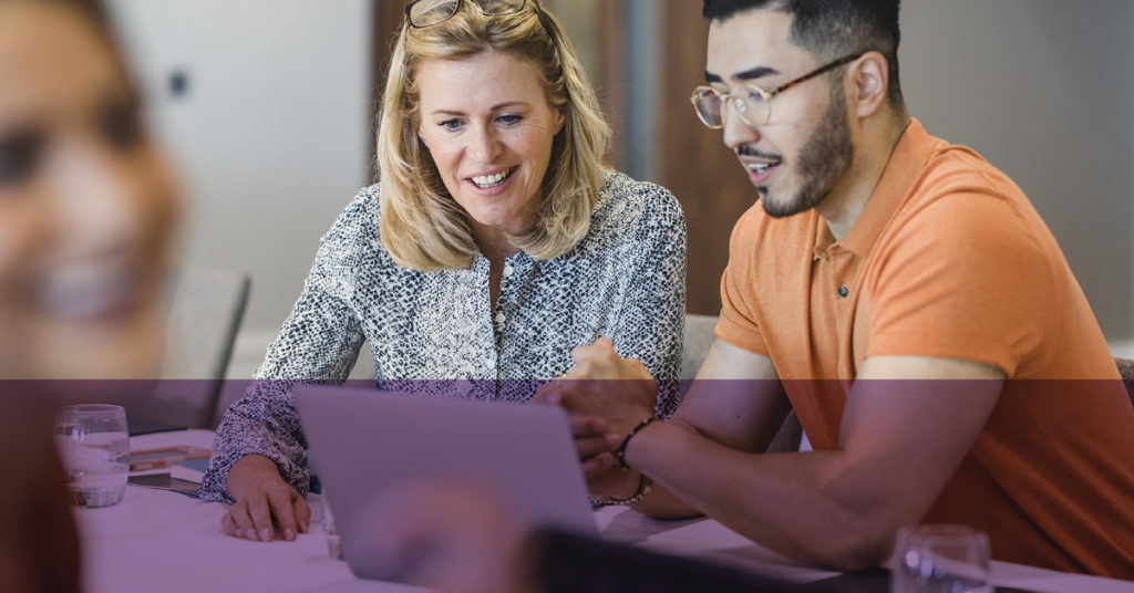 Female Network Rail employee and male student on a summer placement chat animatedly about something on a laptop.