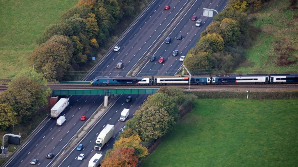 An Avanti West Coast train passing over the M6, daytime