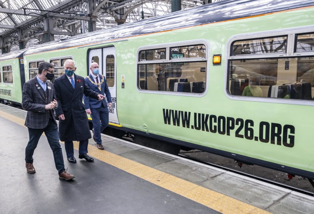 Prince Charles with Martin Frobisher of Network Rail, walking alongside one of the green trains of the future