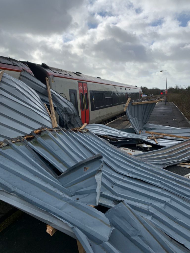 A roof blown onto a platform beside a train at Carmarthen in Wales