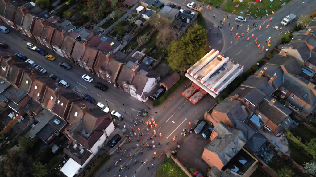 Drone shot of a vehicle driving a large section of a new rail bridge through a residential area in Leamington Spa during our Easter 2022 bank holiday works