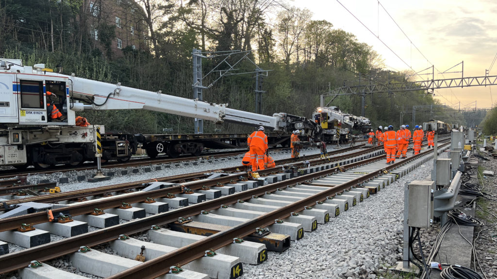 Rail workers in orange on new tracks during track installation at Watford over the Easter 2022 bank holliday