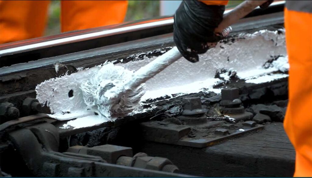 Close up of Network Engineers painting the rails white.