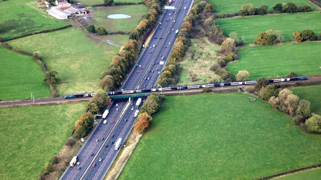 Aerial view of an Avanti West Coast train passing over the M6