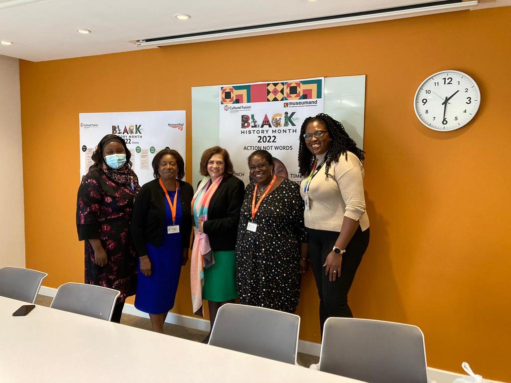 Six members of our employee network Cultural Fusion gathered behind a meeting room table.